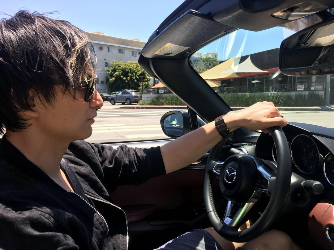 Iann driving the car with the roof down